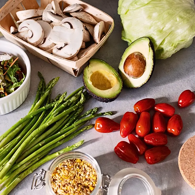 blockchain-food-safety-verification-fresh-produce Assorted fresh vegetables including avocado, mushrooms, lettuce, and tomatoes arranged on a countertop, representing traceable food safety and blockchain-enabled compliance